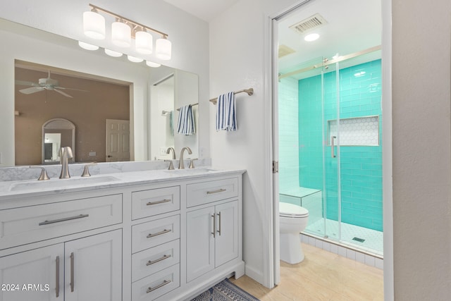 bathroom featuring a shower with door, toilet, ceiling fan, tile patterned floors, and vanity