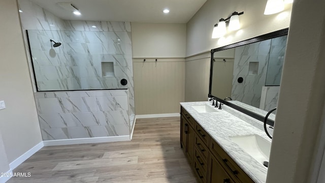 bathroom featuring hardwood / wood-style flooring, vanity, and a tile shower