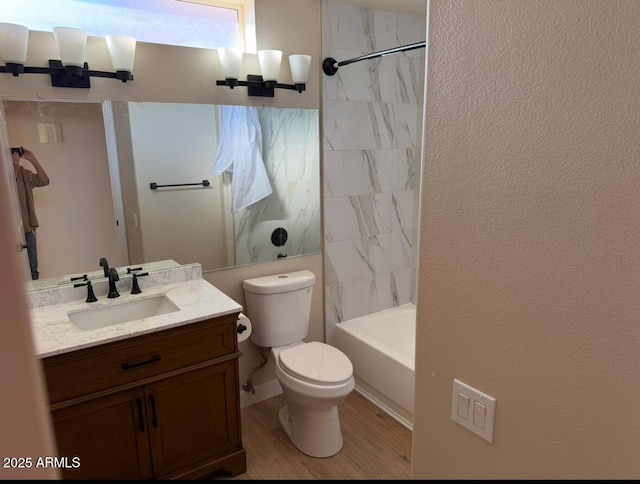 full bathroom with wood-type flooring, toilet, vanity, and tiled shower / bath