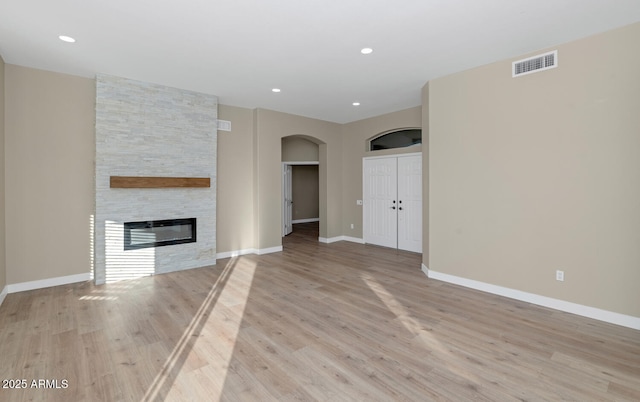 unfurnished living room with light wood-type flooring and a fireplace