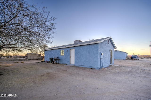 back house at dusk featuring central air condition unit