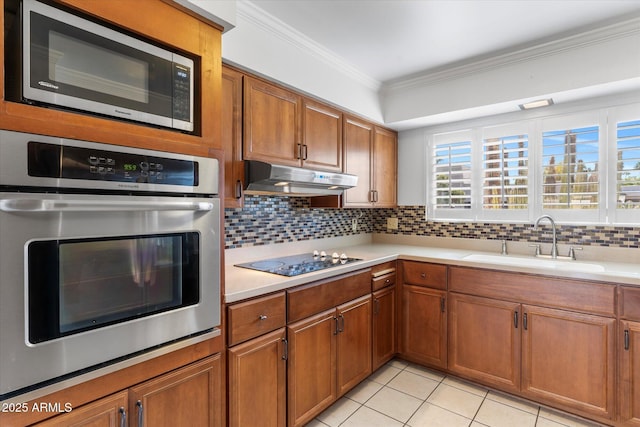 kitchen with tasteful backsplash, sink, light tile patterned floors, stainless steel appliances, and crown molding