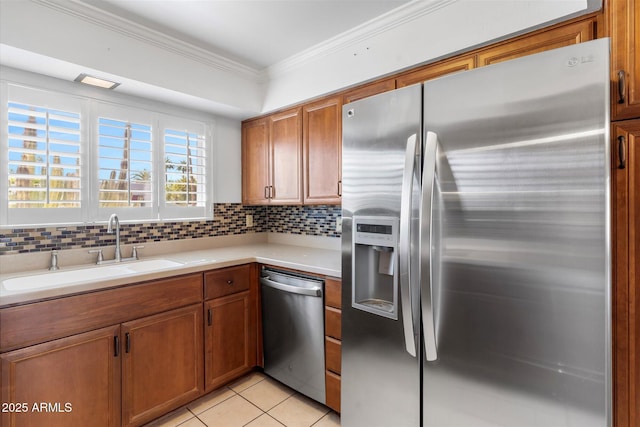 kitchen featuring sink, crown molding, tasteful backsplash, light tile patterned floors, and appliances with stainless steel finishes