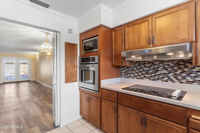 kitchen with french doors, crown molding, tasteful backsplash, decorative light fixtures, and appliances with stainless steel finishes