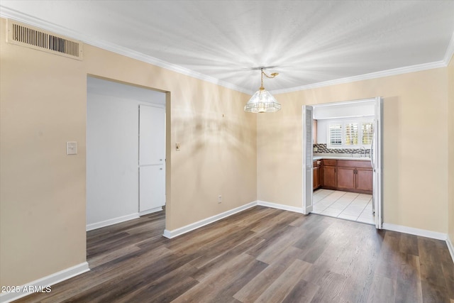 unfurnished dining area with hardwood / wood-style flooring, ornamental molding, and a notable chandelier