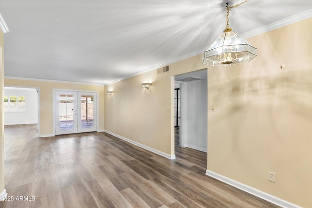 empty room featuring french doors, ornamental molding, and wood-type flooring