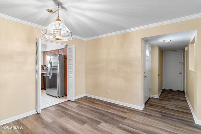 unfurnished dining area with hardwood / wood-style flooring, ornamental molding, and a notable chandelier