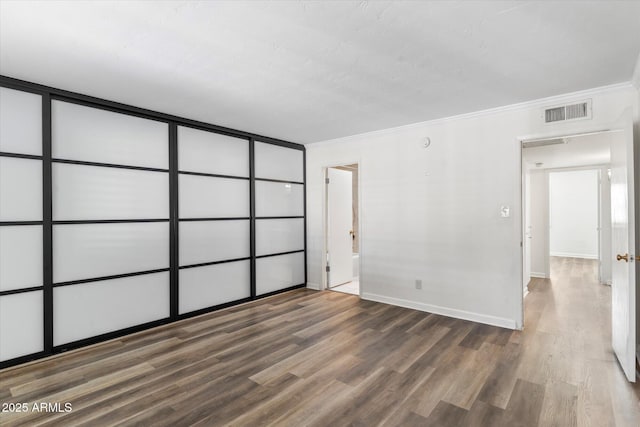 spare room featuring hardwood / wood-style flooring and ornamental molding