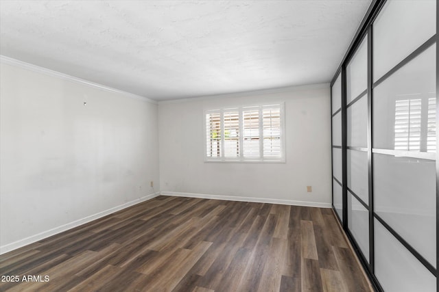 spare room with crown molding, dark hardwood / wood-style flooring, and a textured ceiling