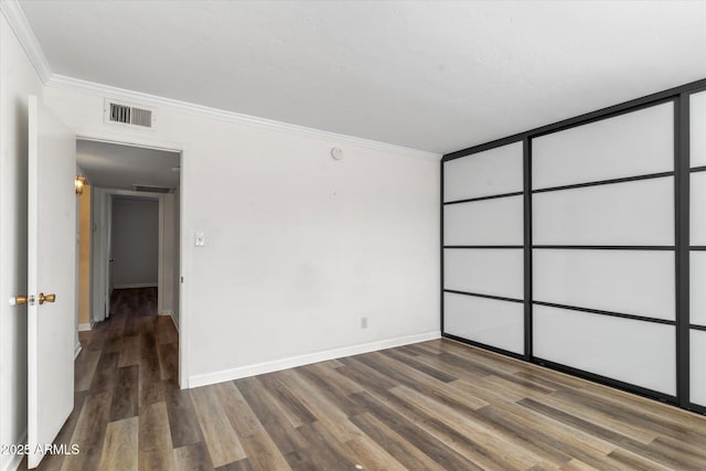 spare room featuring dark wood-type flooring and ornamental molding