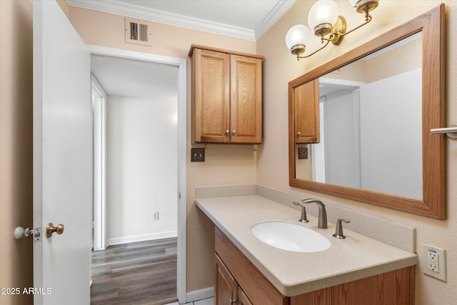 bathroom with hardwood / wood-style flooring, ornamental molding, and vanity