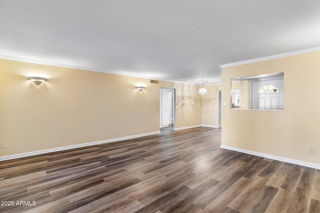 spare room featuring ornamental molding and dark hardwood / wood-style flooring