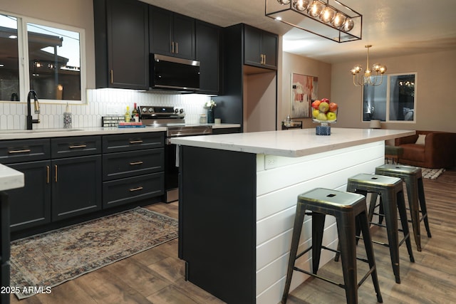 236 E Minton Dr, Tempe, AZ 85282 - kitchen featuring stainless steel appliances, a chandelier, dark wood finished floors, tasteful backsplash, and dark cabinets