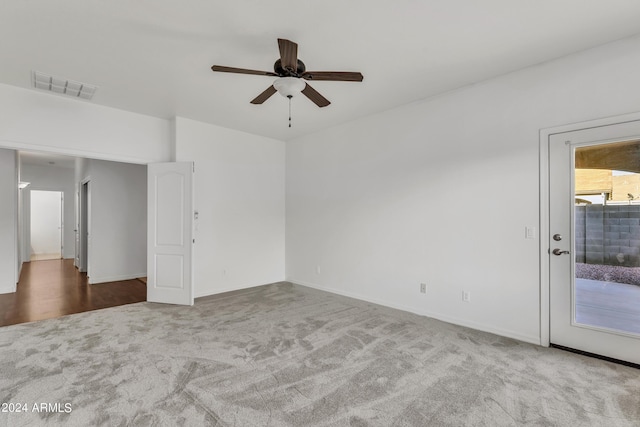 carpeted spare room with visible vents and ceiling fan