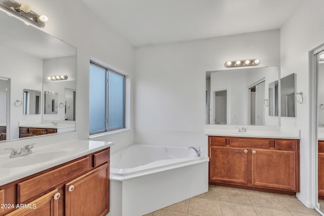 bathroom with a sink, two vanities, a bath, and tile patterned floors