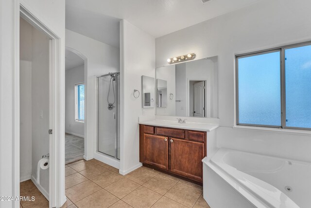 full bathroom featuring a shower stall, baseboards, a bath, tile patterned floors, and vanity