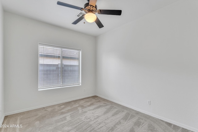 spare room with light carpet, baseboards, and a ceiling fan