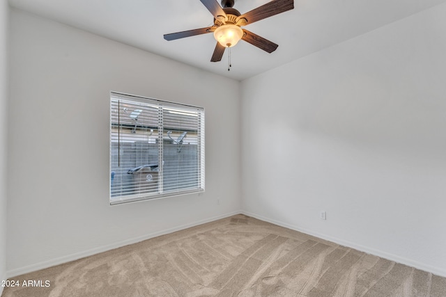 carpeted empty room featuring baseboards and ceiling fan