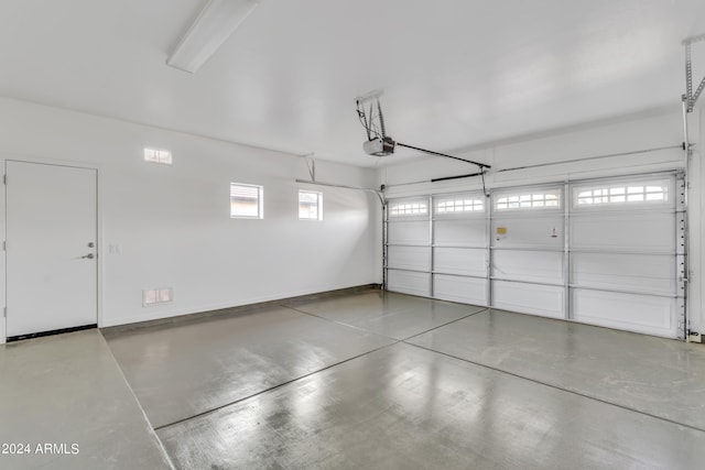 garage featuring a garage door opener and baseboards