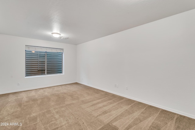 carpeted empty room featuring visible vents and baseboards