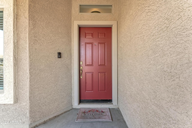 doorway to property featuring stucco siding