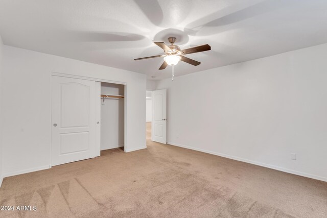 unfurnished bedroom with a closet, baseboards, a ceiling fan, and carpet flooring