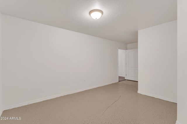 empty room with baseboards and finished concrete flooring