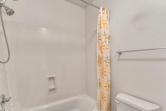 full bathroom featuring shower / tub combo with curtain and toilet