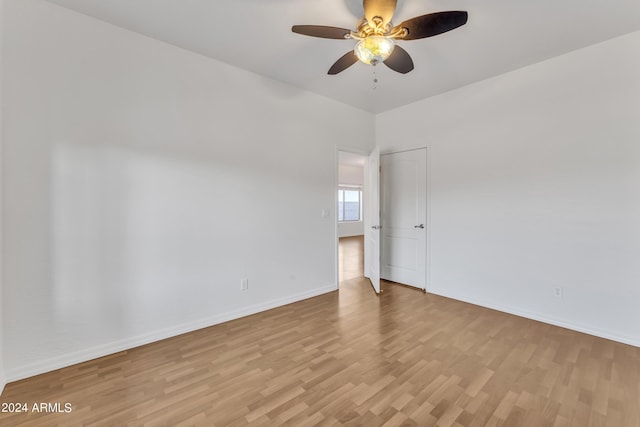 spare room with a ceiling fan, wood finished floors, and baseboards