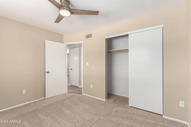 unfurnished bedroom with ceiling fan, a closet, and light colored carpet