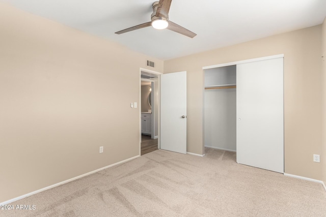 unfurnished bedroom featuring a closet, light colored carpet, and ceiling fan