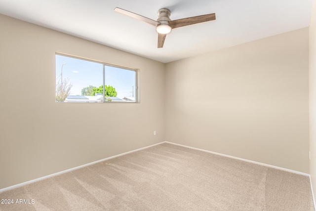 carpeted spare room with ceiling fan