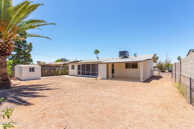 back of house featuring a storage shed and central air condition unit