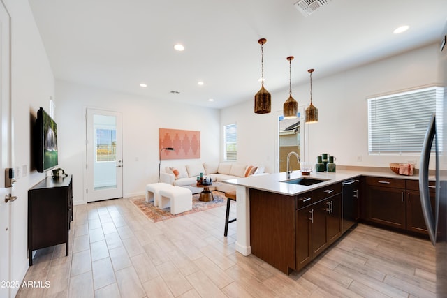 7854 W Tether Trl, Peoria, AZ 85383 - kitchen with a sink, dishwasher, dark brown cabinets, a peninsula, and a kitchen breakfast bar