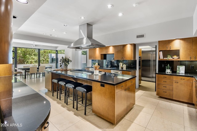 kitchen with island exhaust hood, recessed lighting, visible vents, stainless steel appliances, and a sink
