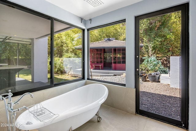 interior space featuring a freestanding bath, visible vents, and tile patterned floors