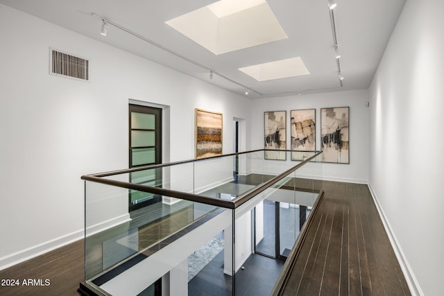 corridor featuring track lighting, a skylight, and visible vents