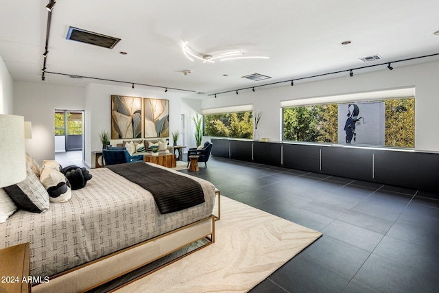 tiled bedroom with visible vents, multiple windows, and rail lighting
