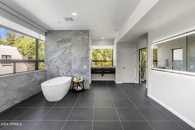 bathroom with visible vents, tile walls, a soaking tub, recessed lighting, and tile patterned flooring