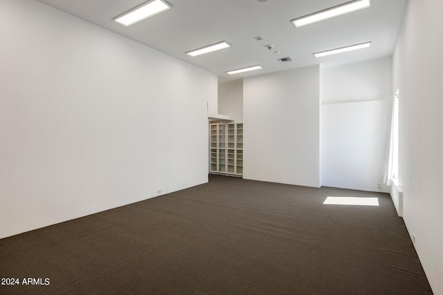 empty room featuring dark colored carpet and visible vents