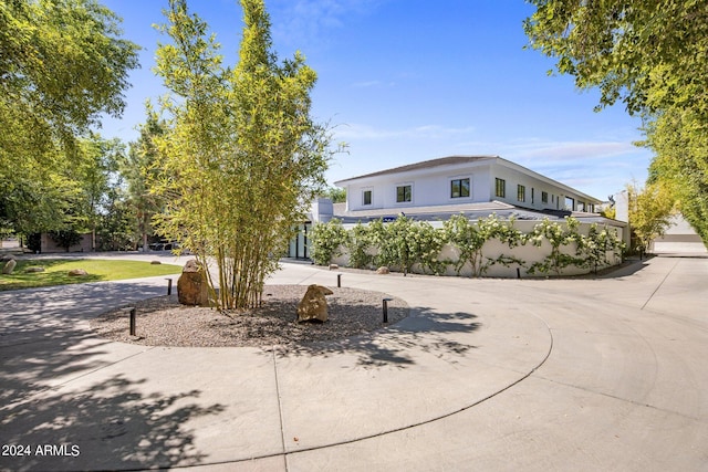 exterior space with curved driveway and stucco siding