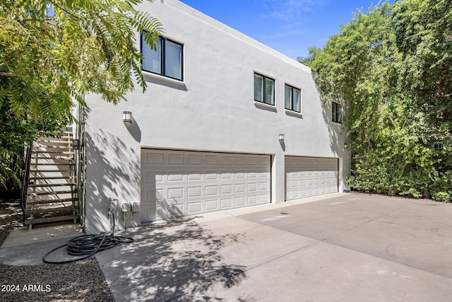 view of home's exterior featuring an attached garage, driveway, and stucco siding