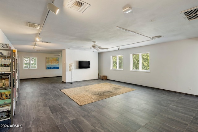 unfurnished living room with ceiling fan and a wealth of natural light