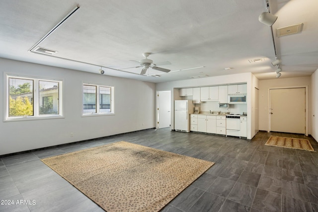 unfurnished living room featuring ceiling fan, rail lighting, and visible vents