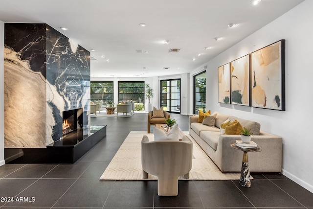 living room with visible vents, recessed lighting, a premium fireplace, tile patterned floors, and baseboards