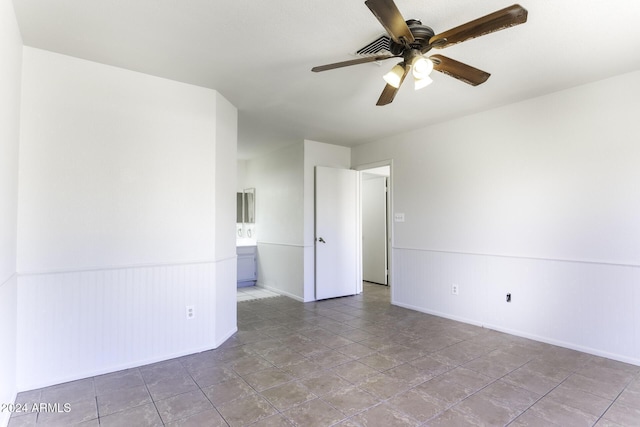 spare room with ceiling fan and light tile patterned floors