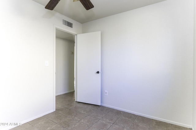 tiled spare room with ceiling fan