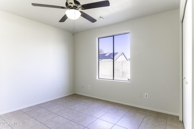 tiled spare room featuring ceiling fan