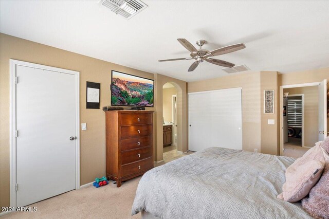 carpeted bedroom with connected bathroom and ceiling fan