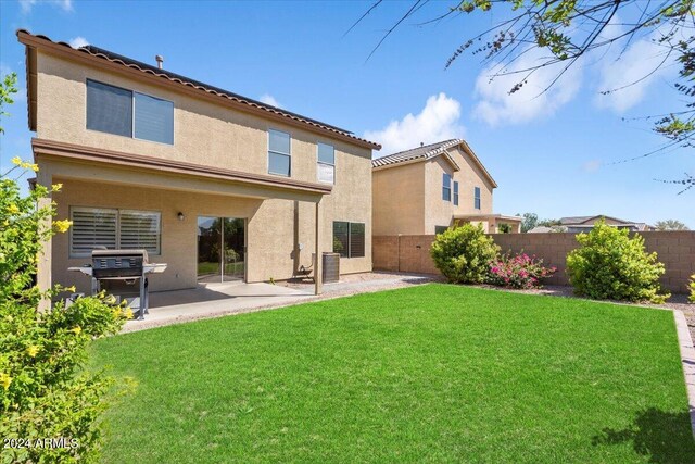 back of house with central AC, a lawn, and a patio